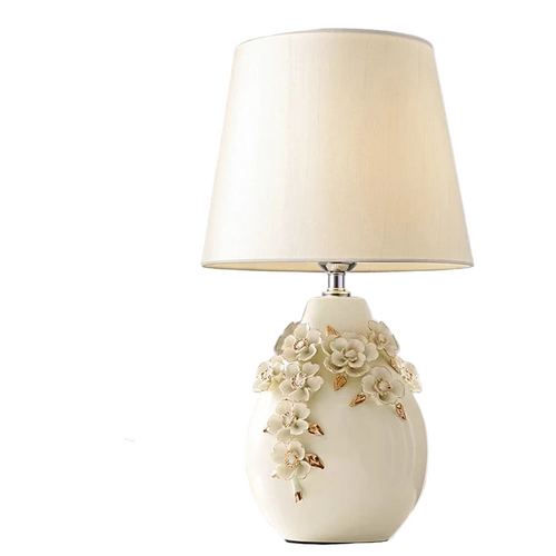 Decorative table lamp with floral design on a neutral background