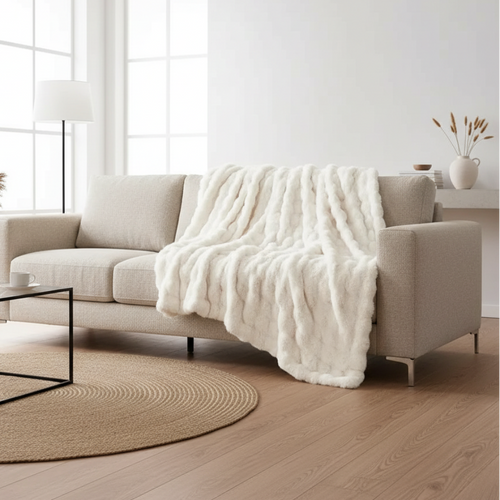 White bed with fluffy comforter and pillows in a bedroom setting