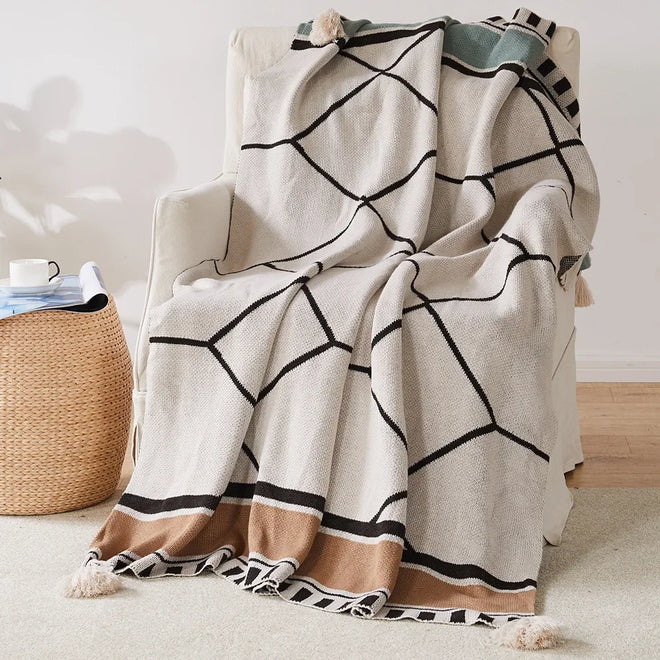 Soft ethnic striped bohemian throw blanket by The Finishing Touch Decor with colorful, woven pattern and fringed edges.
