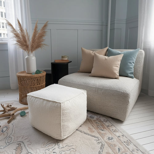 Beautiful boucle pouf ottoman by The Finishing Touch Decor, round foot rest with lightweight, cozy textured fabric for living room decor.