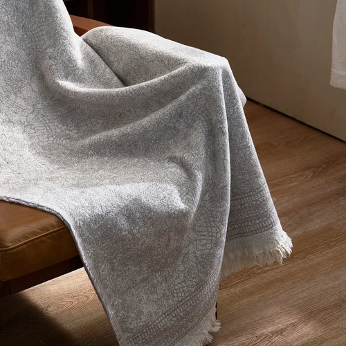 Light grey gauze blanket made of pure cotton by The Finishing Touch Decor, showing soft, breathable fabric with a gentle drape.
