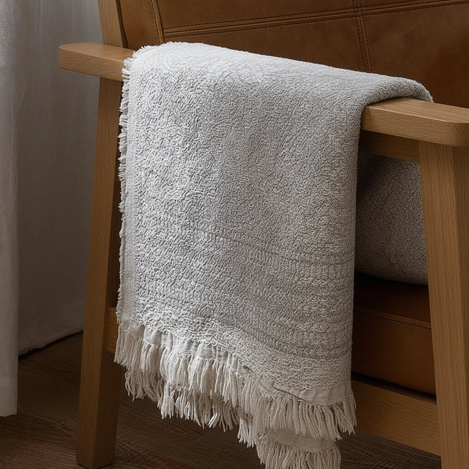 Light pure cotton grey gauze blanket from The Finishing Touch Decor, showing soft, breathable fabric with a gentle drape.