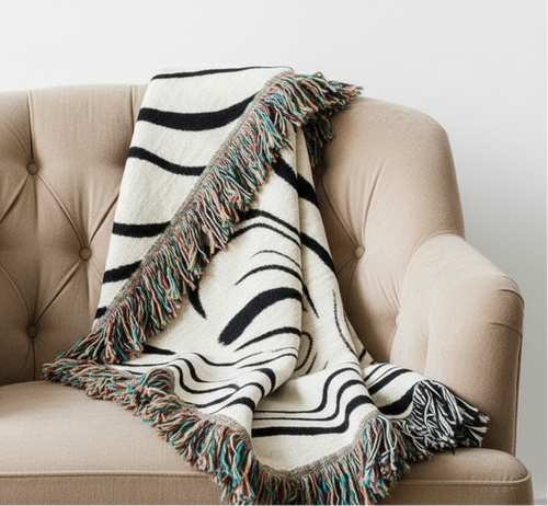 Abstract wavy ink swirl fringed throw blanket from The Finishing Touch Decor, showcasing a vibrant, artistic design with fringed edges.