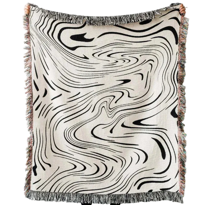 Abstract wavy ink swirl fringed throw blanket by The Finishing Touch Decor, showing a soft, textured blanket with fringed edges.
