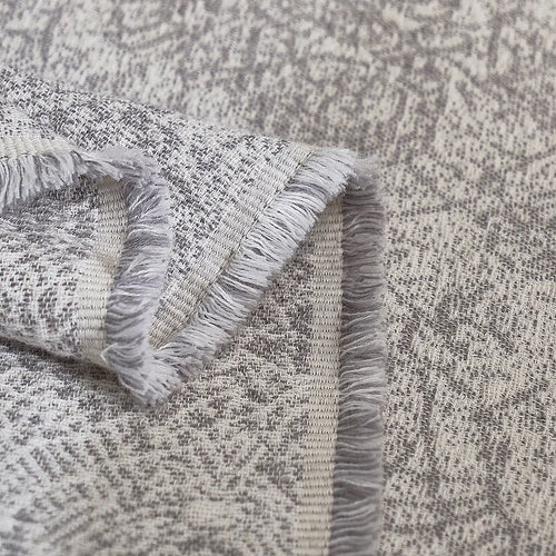 Light grey pure cotton gauze blanket from The Finishing Touch Decor, soft and breathable fabric, draped on a bed or sofa.
