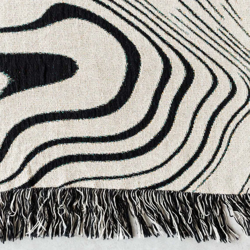Abstract wavy ink swirl fringed throw blanket from The Finishing Touch Decor, featuring a flowing ink-inspired design and fringed edges.