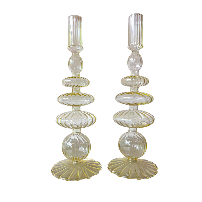 Two tall, decorative glass candle holders on a white background