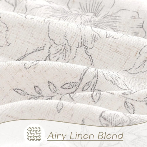 Vintage ecru and grey floral sketch pattern farmhouse curtains by The Finishing Touch Decor hanging on a window.