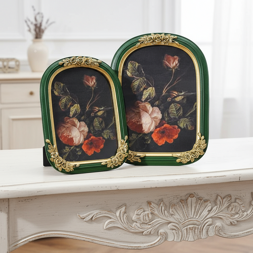Two decorative picture frames with floral designs on a white surface.