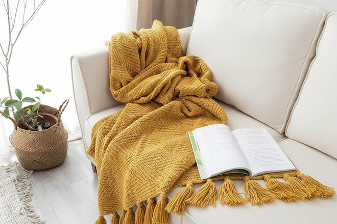 Saffron yellow knit throw blanket with tassels from The Finishing Touch Decor, cozy and large for added warmth and style.